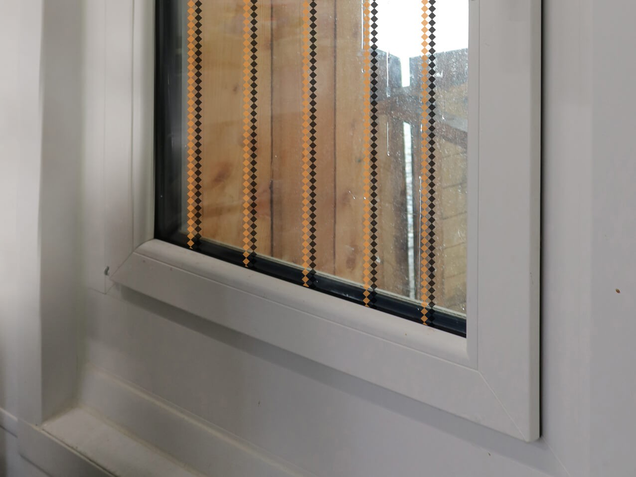 Vogelschutzfolie birdsafe Vogelschutzfolie-birdsafe-Rautenraster-orange-schwarz-Fensterglas